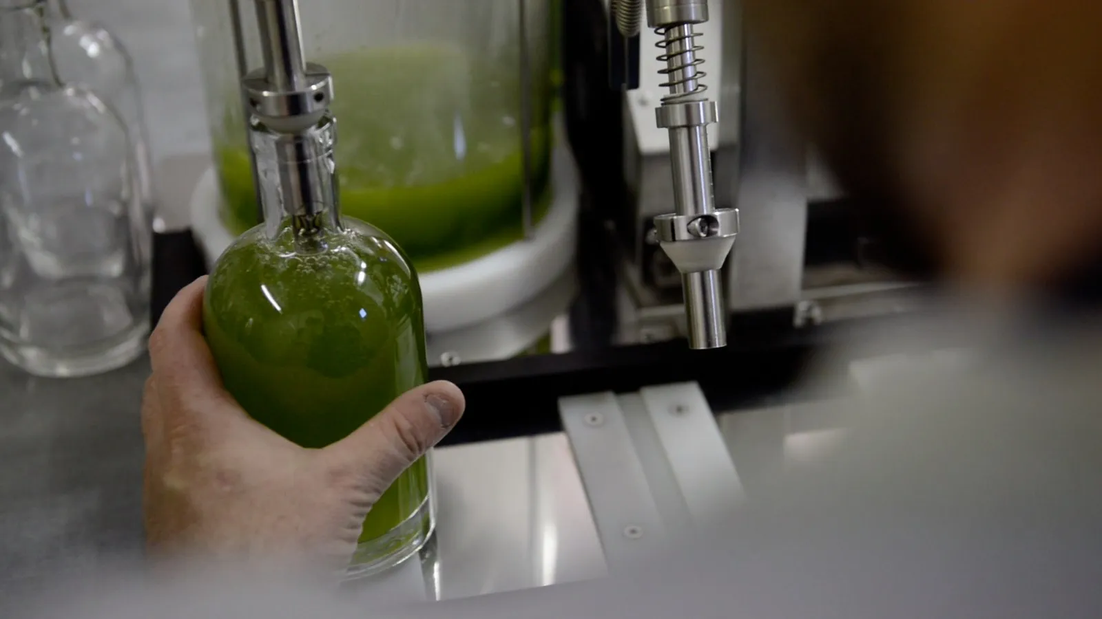 Embouteillage à la main d'une liqueur verte